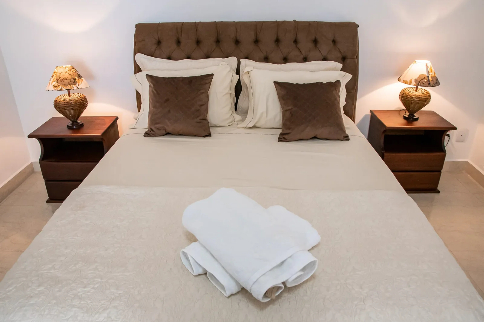 Quarto de casal da Casa Sede — cabeceira estofada e luminárias de cabeceira