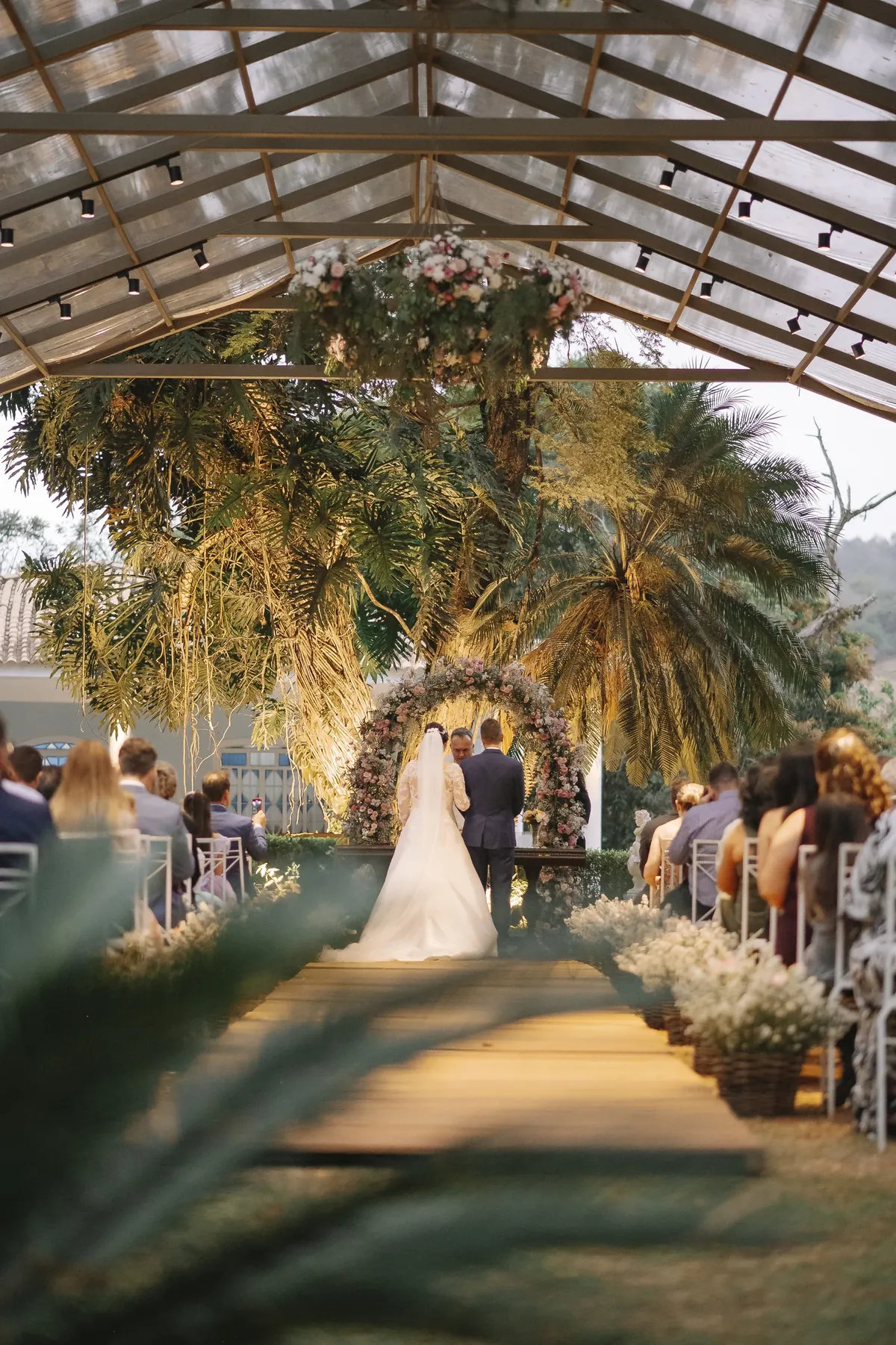 Casal no arco de flores sob o gazebo