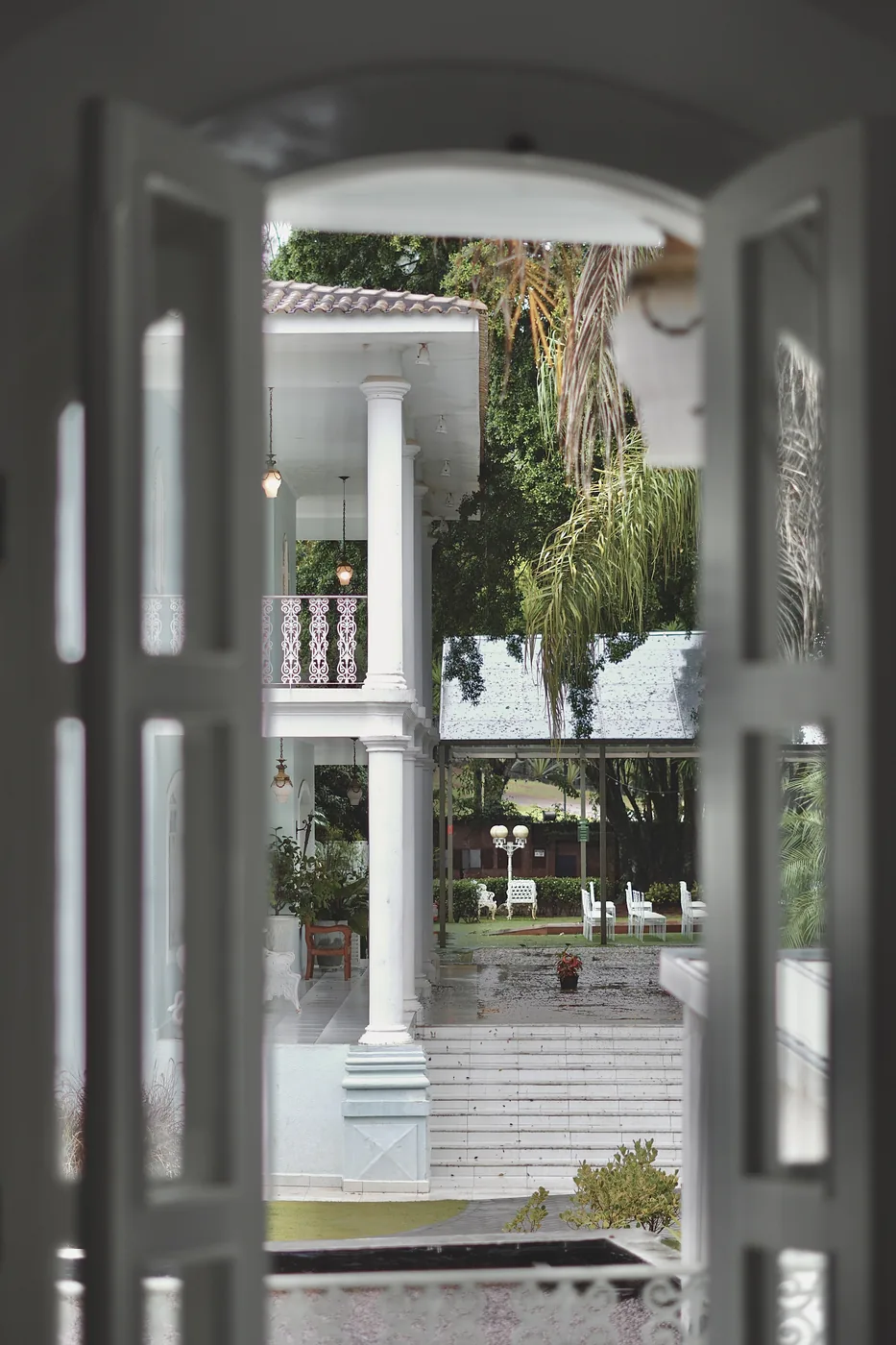 Vista da varanda da Casa Sede para o jardim, com mesas e cadeiras ao fundo
