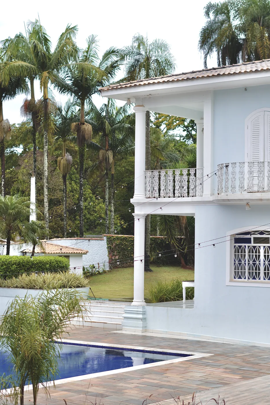 Fachada da Casa Sede com varanda, piscina e jardim