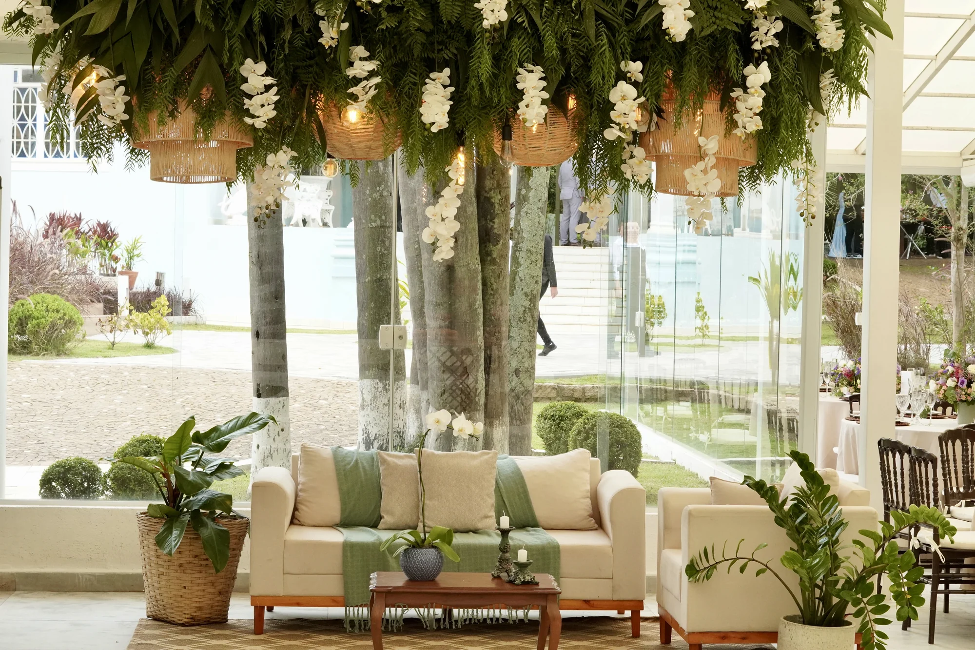 Lounge interno com sofás e plantas penduradas