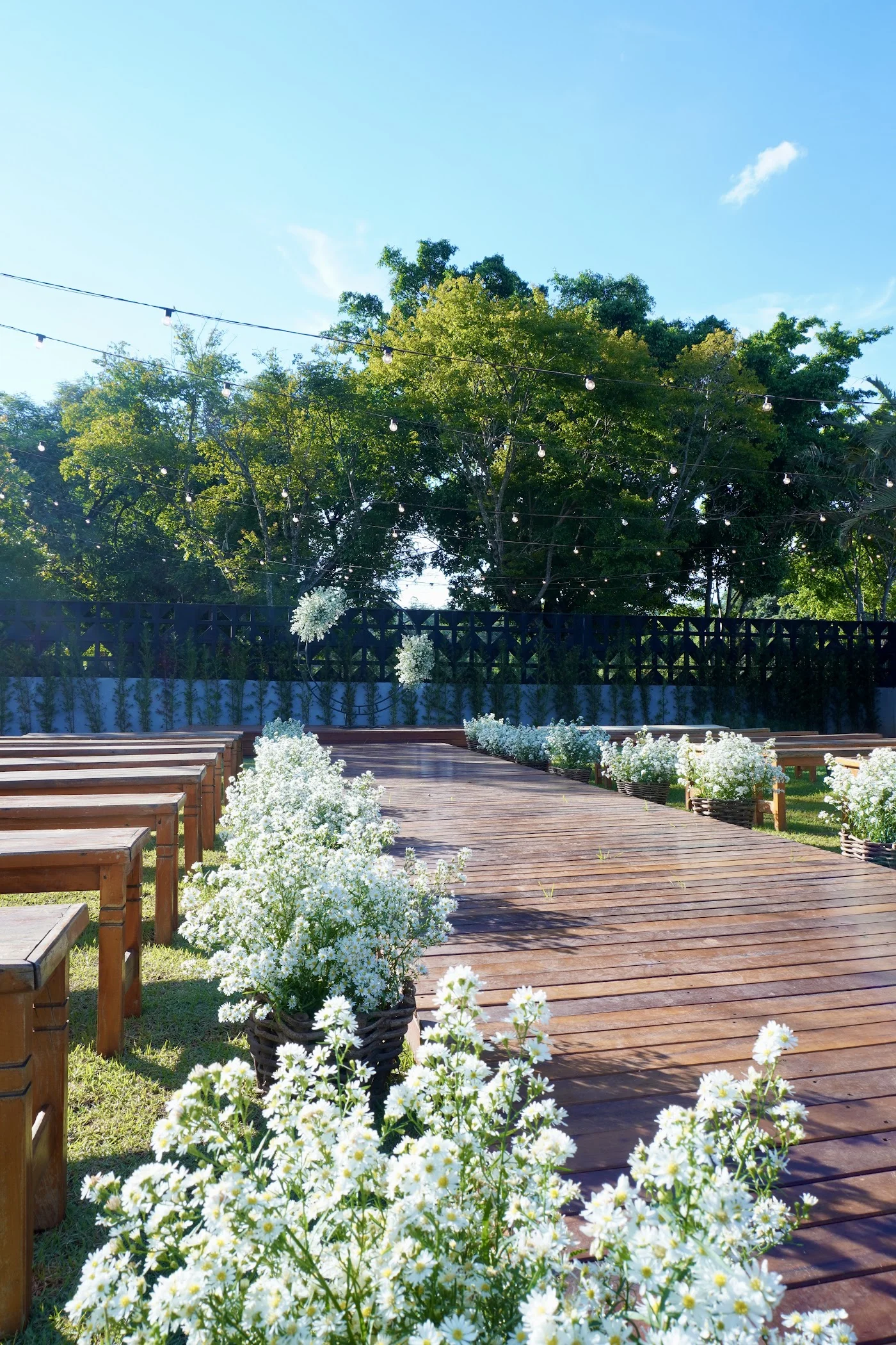 Corredor de cerimônia de madeira com flores brancas no Recanto das Palmeiras