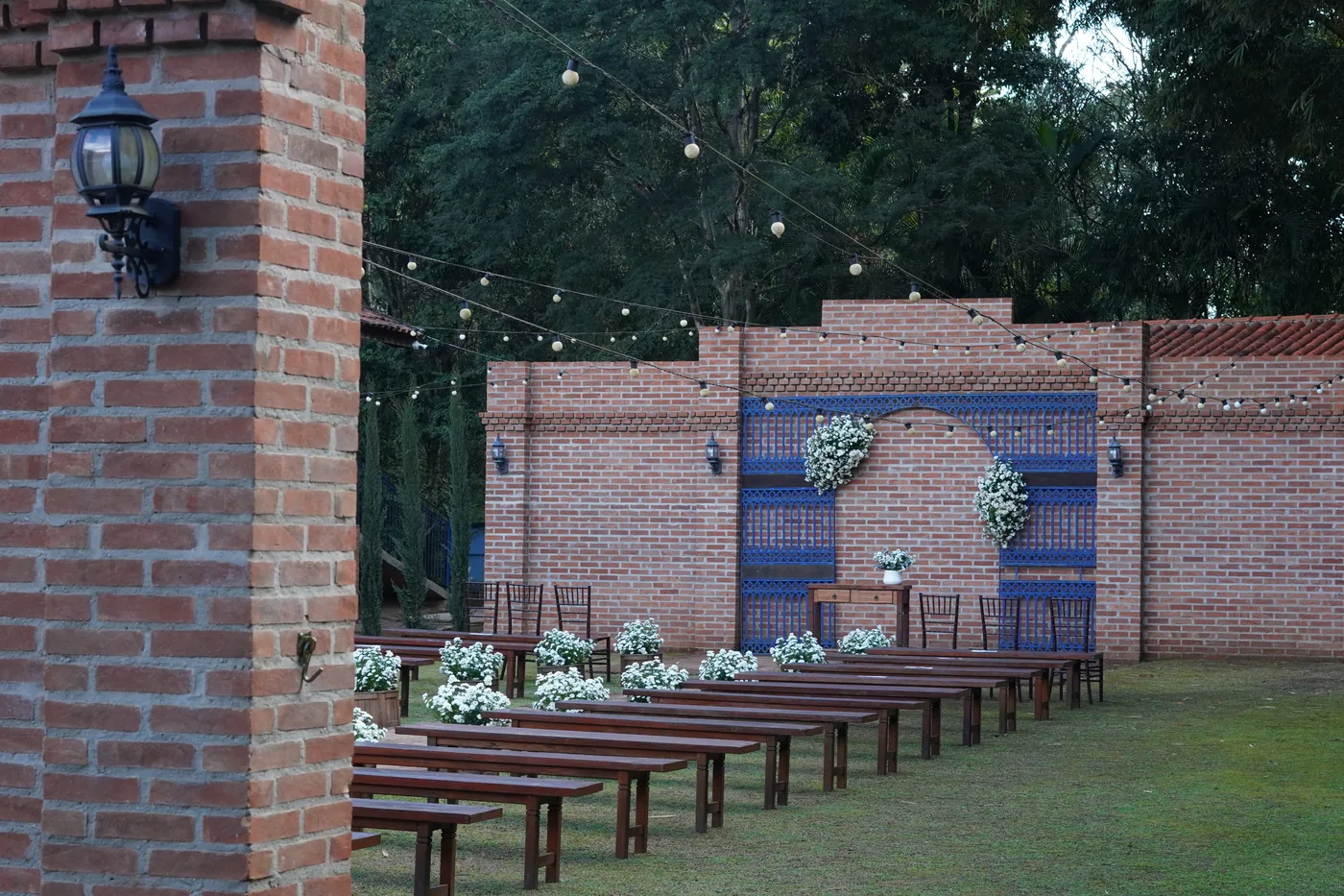Arco de cerimônia com azulejos azuis e flores brancas ao entardecer