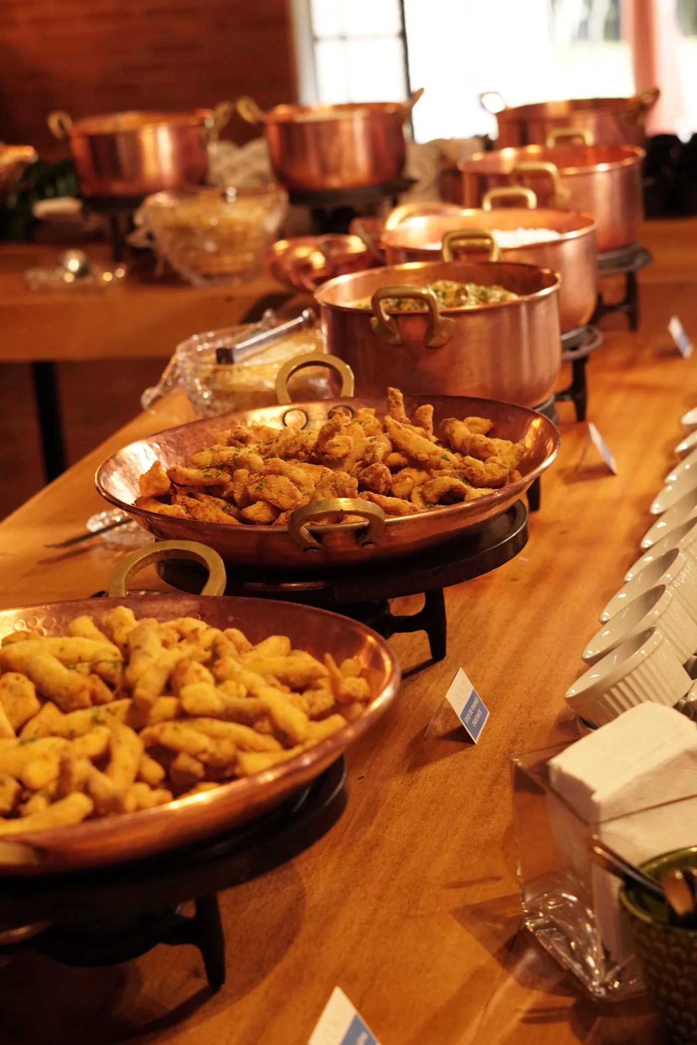 Mesa farta com panelas de cobre no buffet